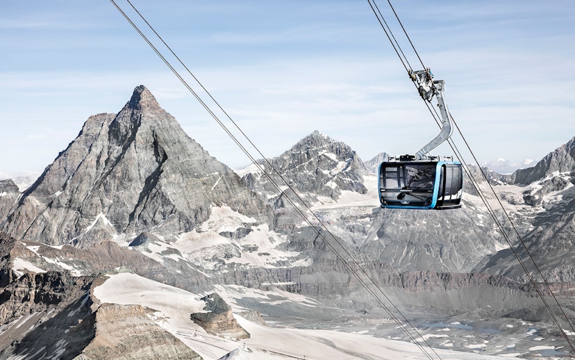 Zermatt cable car ascending towards Matterhorn Glacier Paradise with snow-covered peaks.