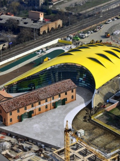 Aerial view of Modena Enzo Ferrari Museum with its distinctive yellow roof in Modena, Italy.