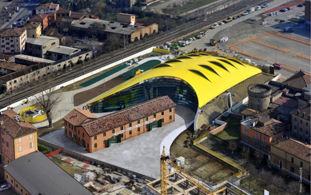 Aerial view of Modena Enzo Ferrari Museum with its distinctive yellow roof in Modena, Italy.