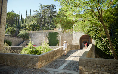 Visitor exploring historic stone walls in Girona, Spain.