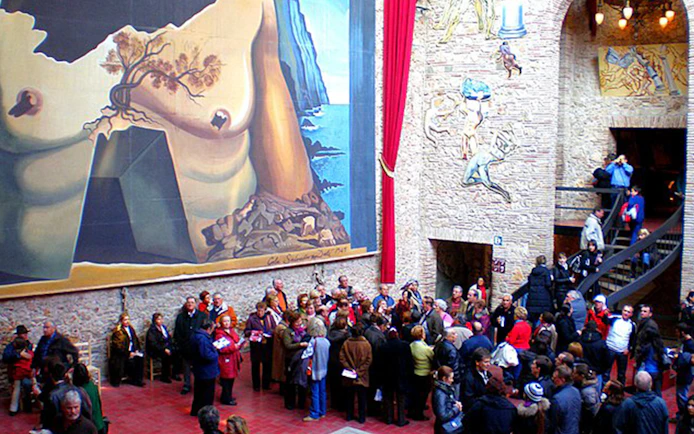 Visitors at Dalí Theatre-Museum in Figueres, viewing surrealist murals and art.