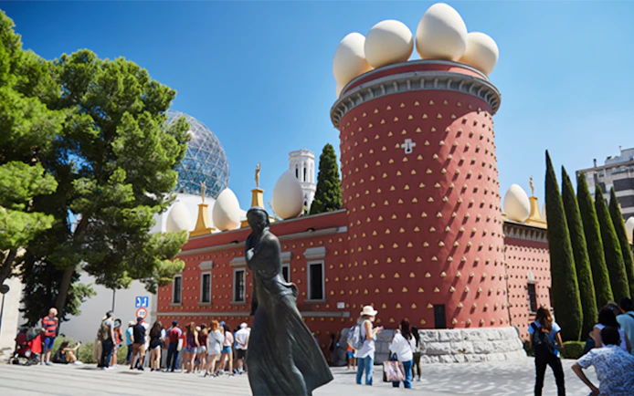 Dalí Theatre-Museum in Figueres with visitors and distinctive egg sculptures.