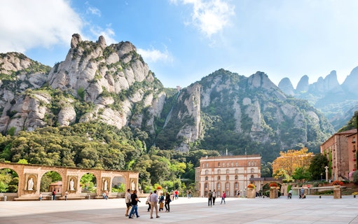 Montserrat mountain view with tourists in courtyard, Catalonia, Spain.