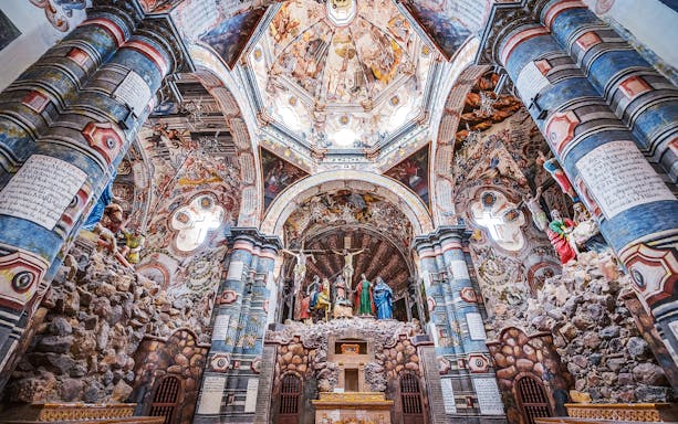 Ornate interior of a Vatican City church with detailed frescoes and sculptures.