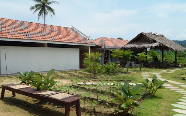 Tropical farm with garden and thatched pavilion in Penang, Malaysia.