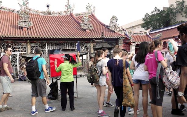 Tourists exploring a historic temple in Georgetown, Penang during a heritage tour.