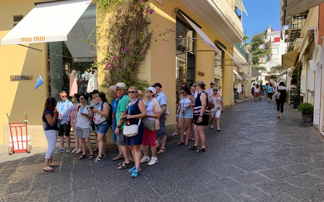 Tour group exploring a street on Capri Island during a guided tour with Sorrento transfers.