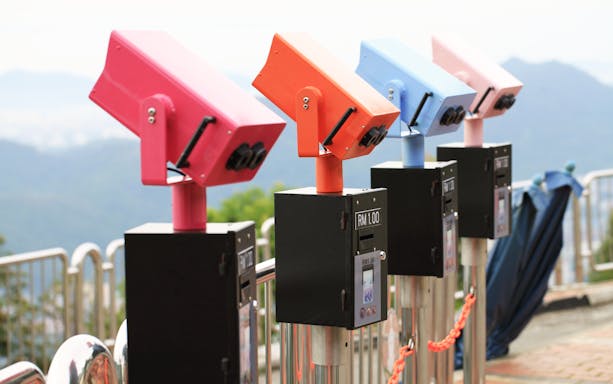 Colorful coin-operated binoculars overlooking Penang's scenic landscape.