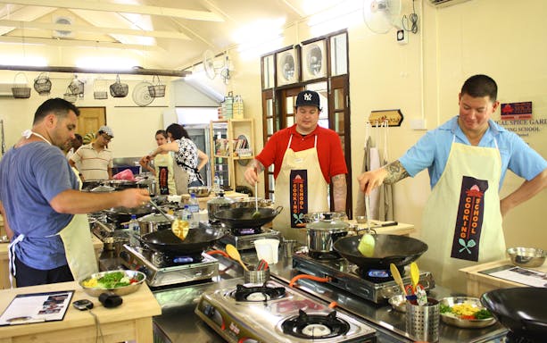 Participants cooking at a Penang local market cooking class.