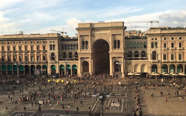 Piazza del Duomo in Milan with crowds and Galleria Vittorio Emanuele II entrance.