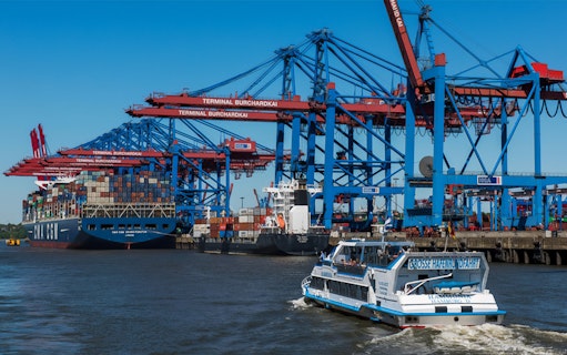 Harbor tour boat passing shipping containers at Terminal Burchardkai, Hamburg.
