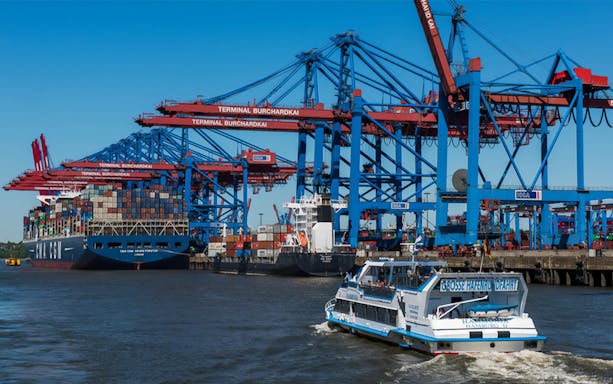 Harbor tour boat passing shipping containers at Terminal Burchardkai, Hamburg.