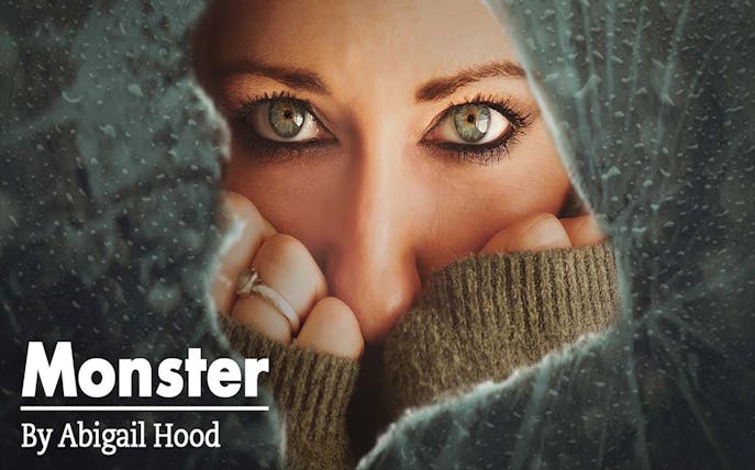 Close-up of a person's eyes peering through a cracked surface, related to "Monster.