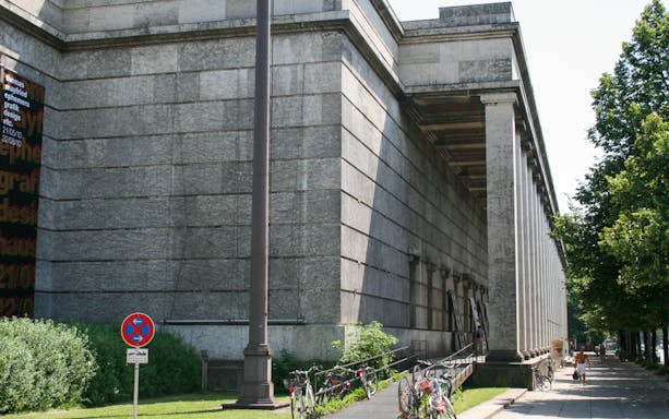 Nazi-era building in Munich with columns and bicycles along the sidewalk.