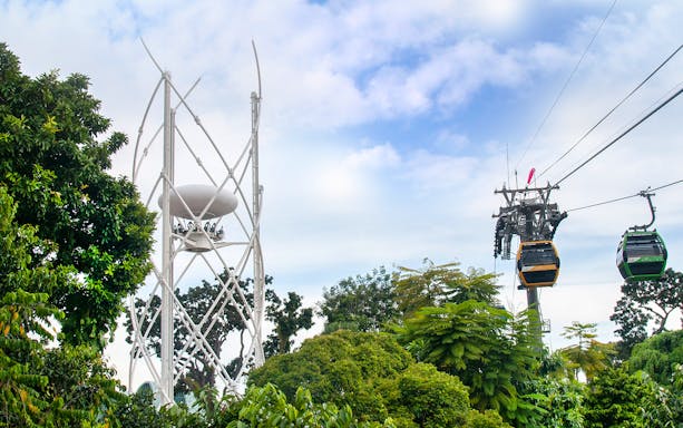 Singapore Cable Car and SkyHelix Sentosa amidst lush greenery.