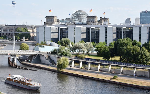 Boat tour on the Spree River with Berlin's Reichstag building in the background.