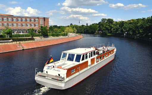 Boat tour on the Spree River in Berlin with cityscape and TV Tower in the background.