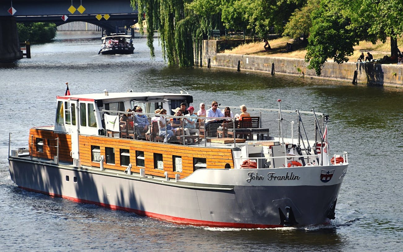 Boat tour on the Spree River in Berlin with passengers enjoying the view.