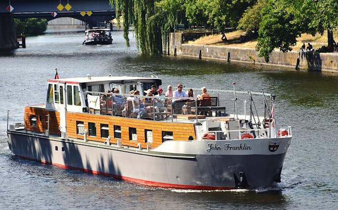 Boat tour on the Spree River in Berlin with passengers enjoying the view.