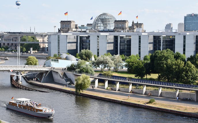 Boat cruising on the Spree River with the Reichstag building in Berlin, Germany.