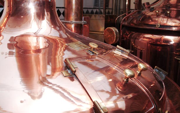 Copper brewing tanks in a brewery during a beer and brewery tour.