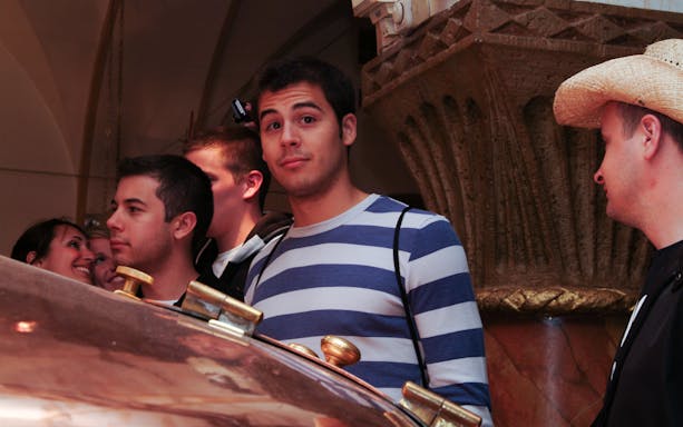 Group of people on a brewery tour examining brewing equipment.