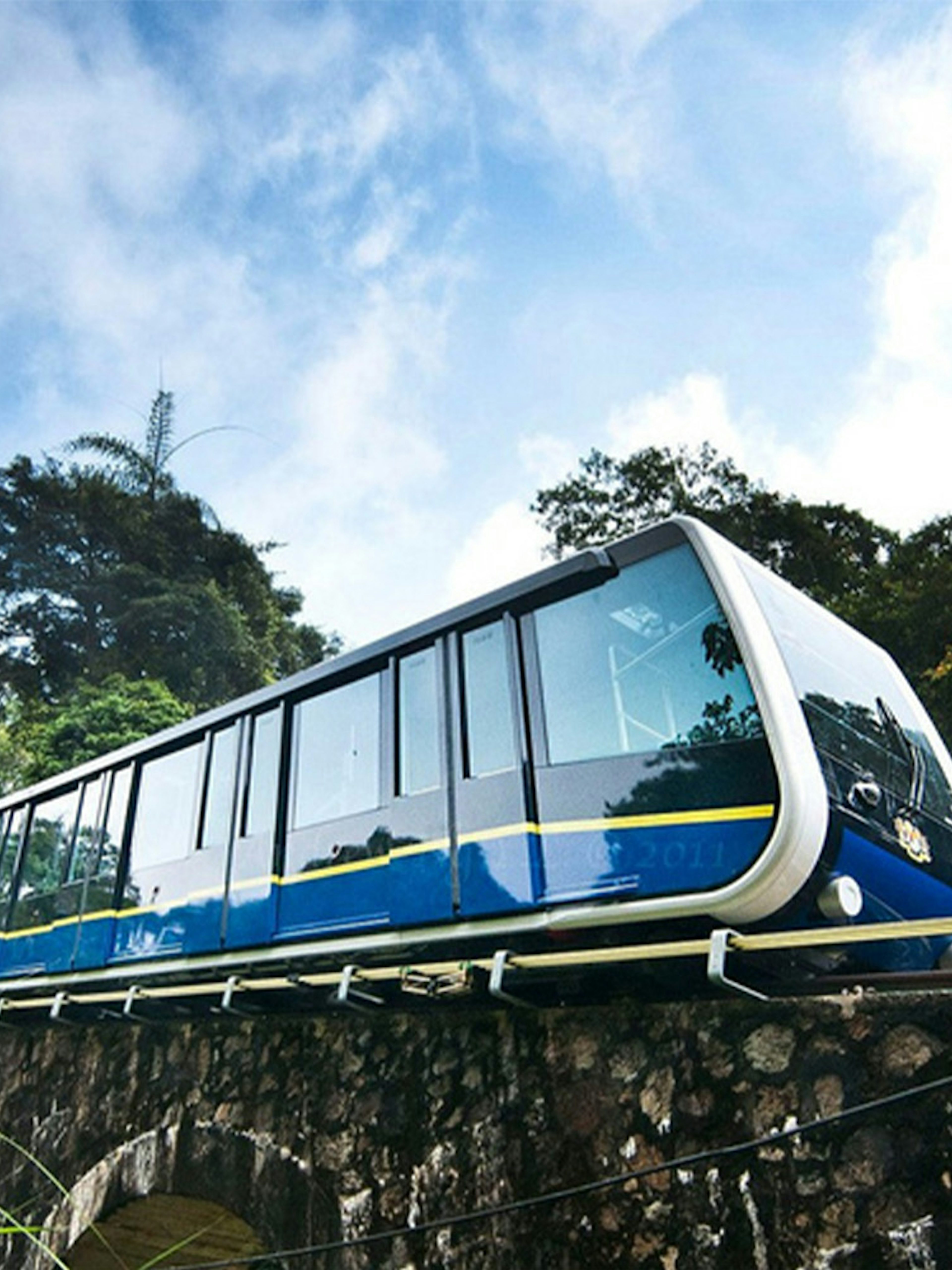 Funicular train ascending Penang Hill amidst lush greenery.