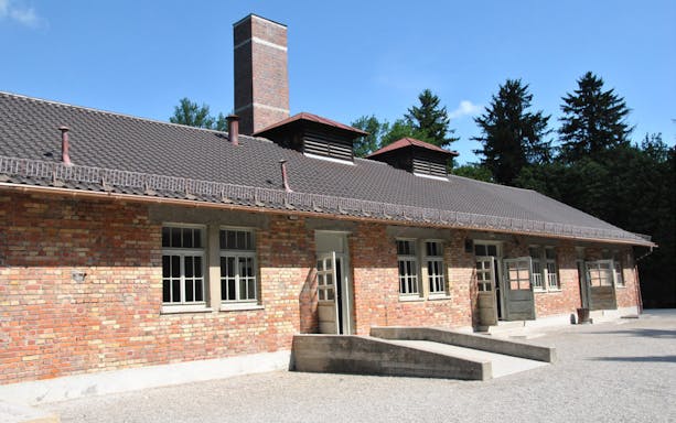Brick building at Dachau Memorial, former concentration camp, with open doors and windows.