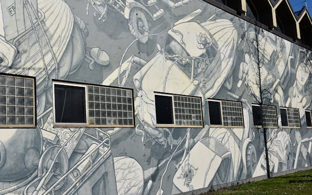 Street art mural depicting mechanical figures on a building in Munich.