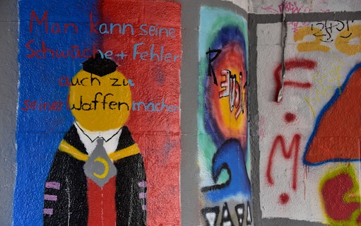 Street art mural with abstract figure and German text in Munich.