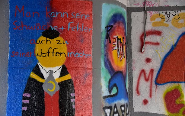 Street art mural with abstract figure and German text in Munich.