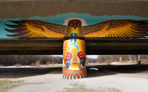 Street art of an eagle with outstretched wings under a bridge in Munich.