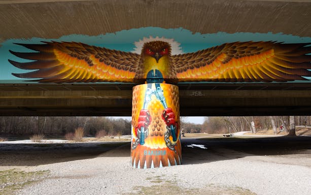 Street art of an eagle with outstretched wings under a bridge in Munich.