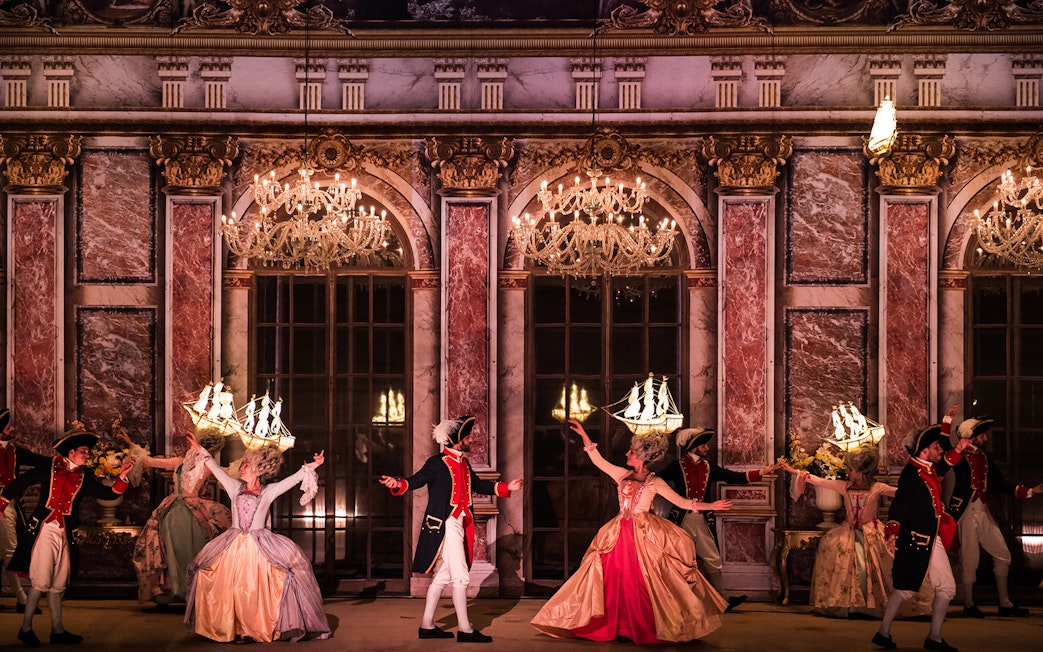 Performers in historical costumes dancing at Puy du Fou Theme Park.