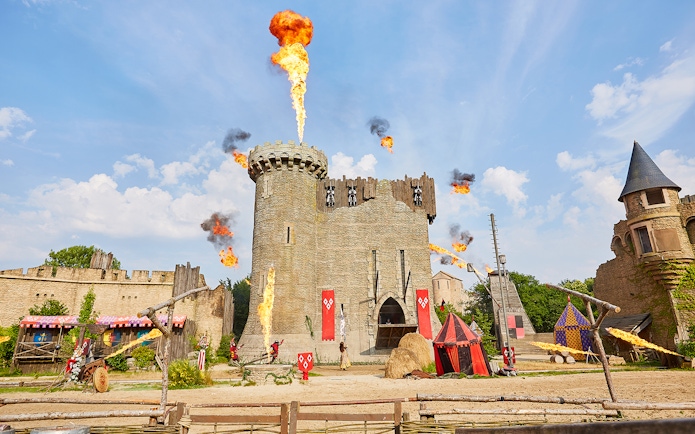 Medieval castle with fire effects at Puy du Fou Theme Park.