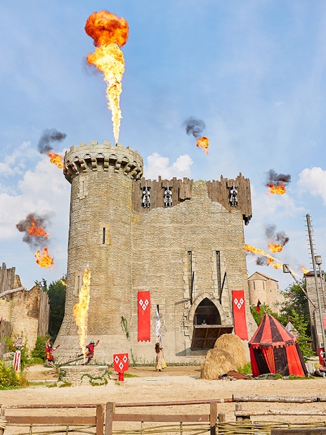 Medieval castle with fire effects at Puy du Fou Theme Park.