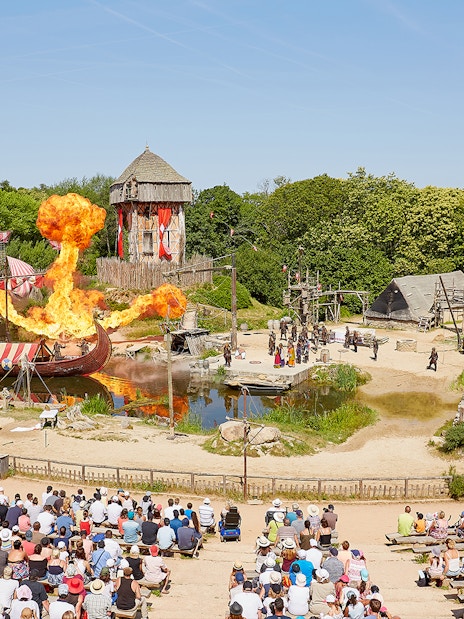 Viking ship battle reenactment with fire effects at Puy du Fou Theme Park, France.