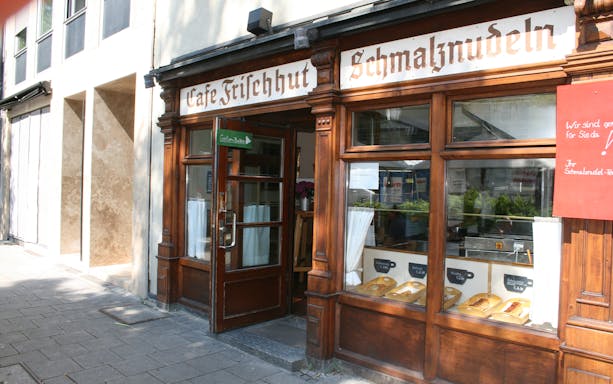 Cafe Frischhut entrance with traditional Bavarian pastries displayed in Munich.