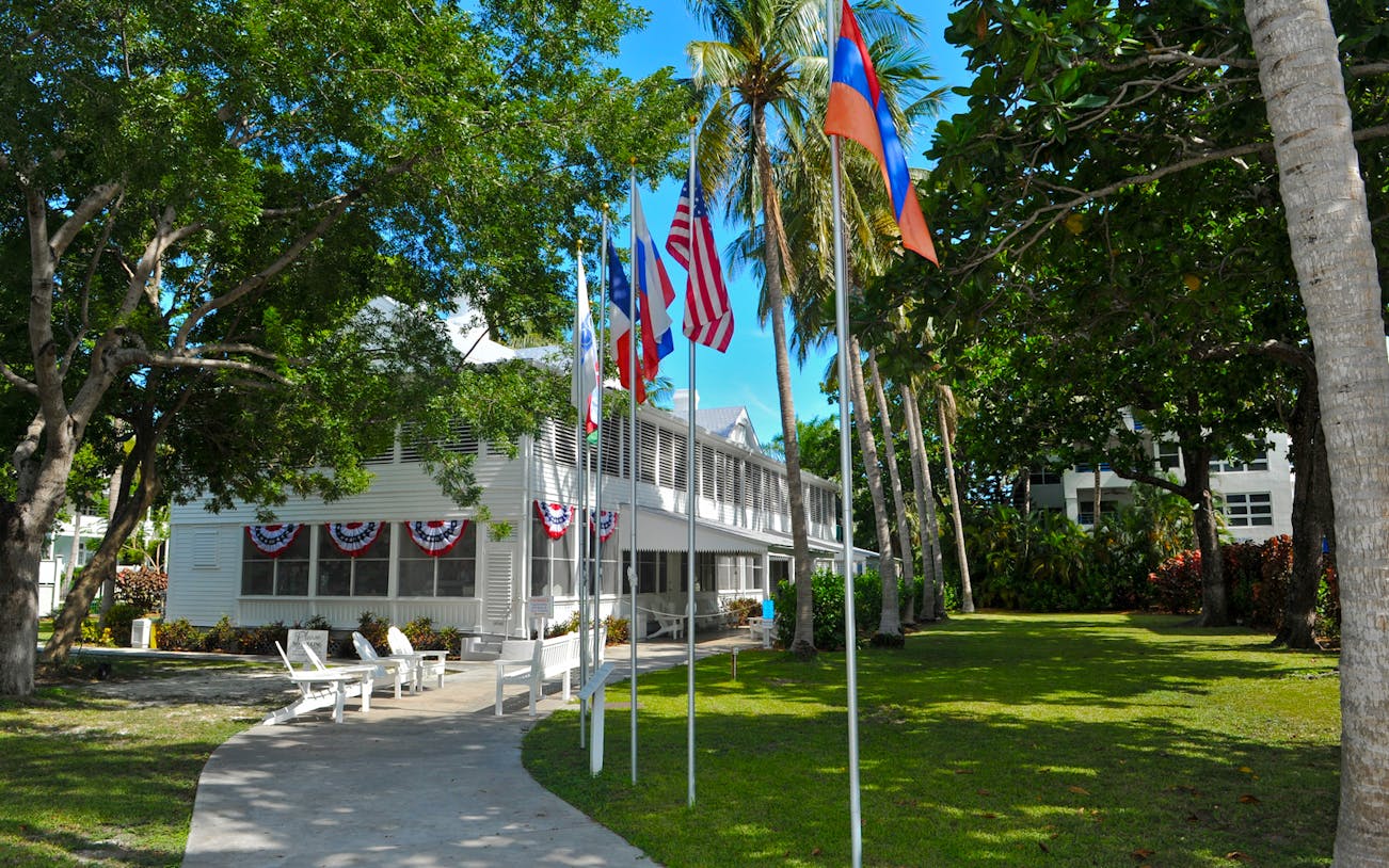 Truman Little White House in Key West with flags and palm trees.