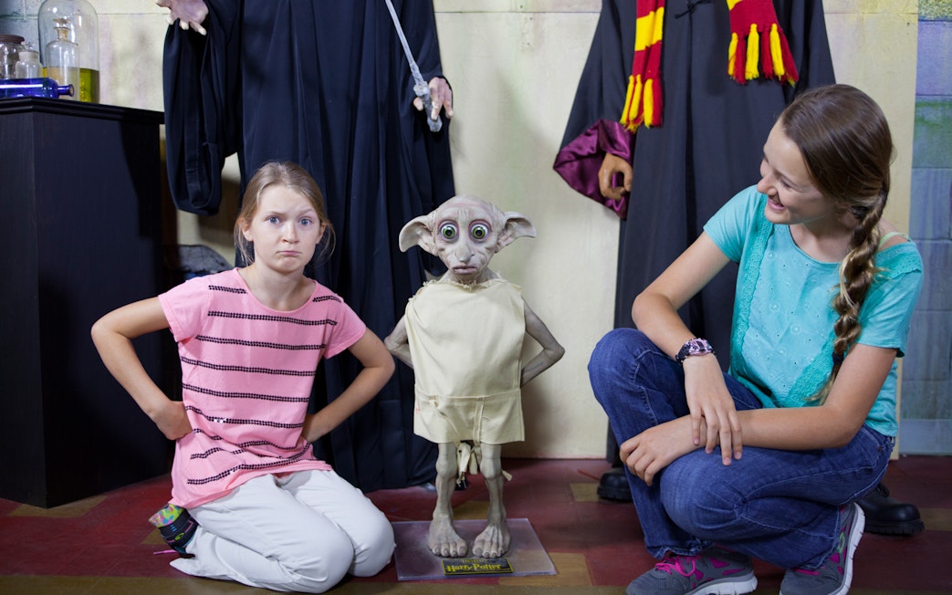 Children posing with a wax figure of a house-elf at St. Augustine Potter's Wax Museum.