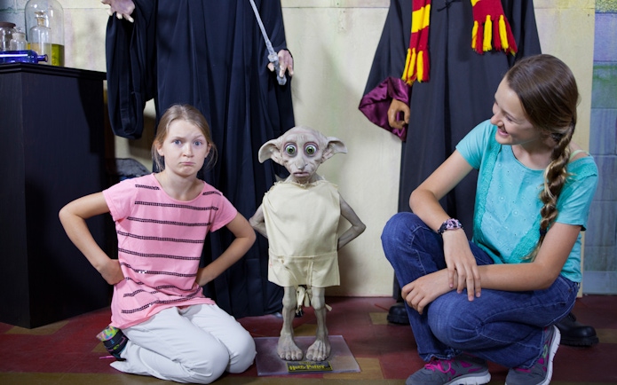 Children posing with a wax figure of a house-elf at St. Augustine Potter's Wax Museum.