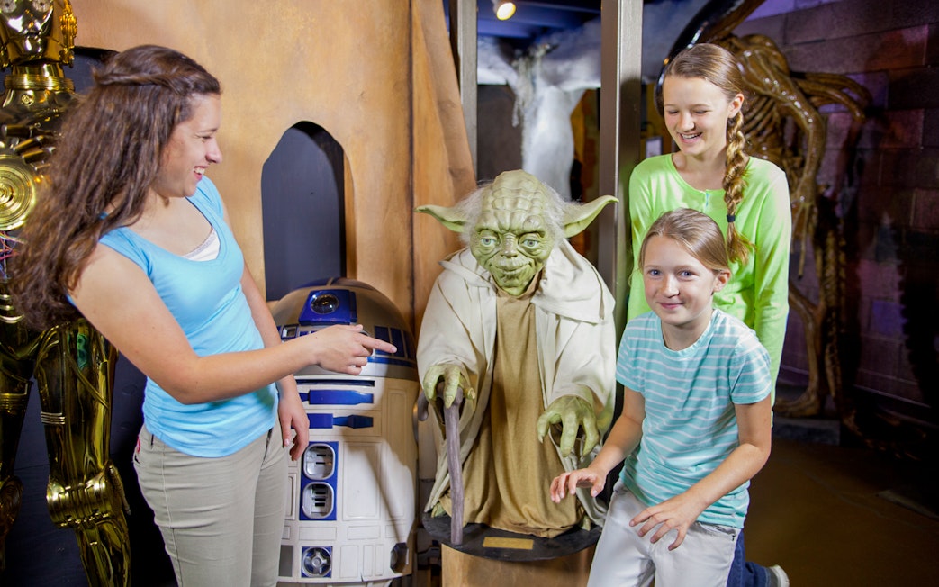 Visitors interacting with wax figures of iconic movie characters at St. Augustine Potter's Wax Museum.