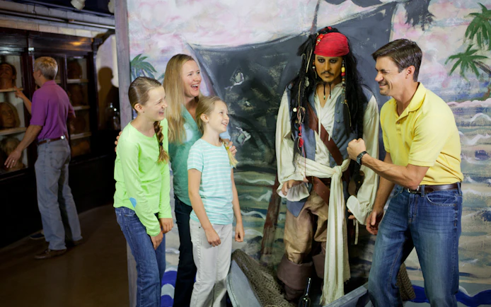 Family posing with pirate wax figure at St. Augustine Potter's Wax Museum.