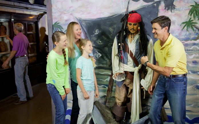 Family posing with pirate wax figure at St. Augustine Potter's Wax Museum.
