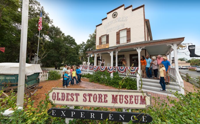 Visitors outside St. Augustine Oldest Store Museum, Florida, observing a historical reenactment.