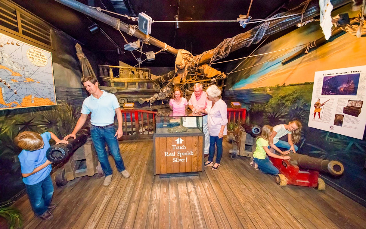 Visitors exploring exhibits at St. Augustine History Museum, featuring Spanish treasure and artifacts.