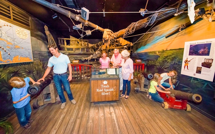 Visitors exploring exhibits at St. Augustine History Museum, featuring Spanish treasure and artifacts.