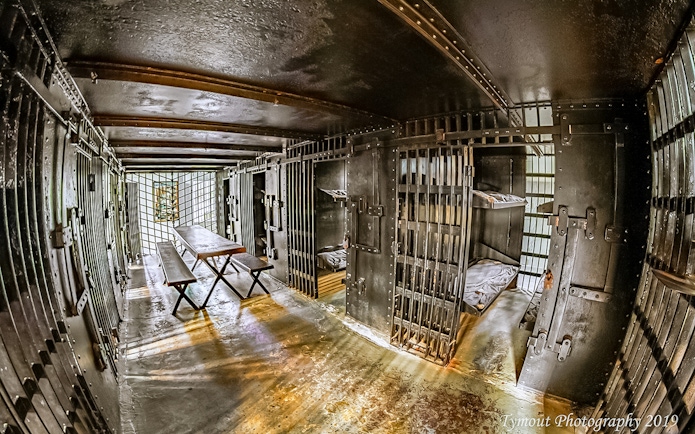 St. Augustine Old Jail Museum cell interior with iron bars and wooden benches.