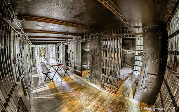 St. Augustine Old Jail Museum cell interior with iron bars and wooden benches.
