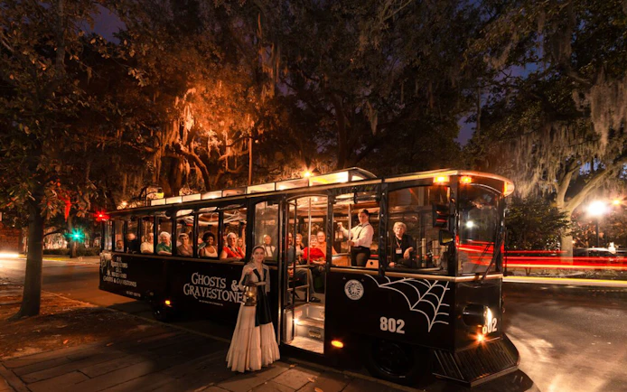 St. Augustine Ghosts & Gravestones tour trolley at night with passengers and guide.